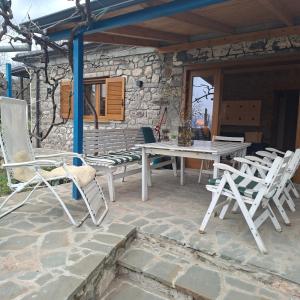 a patio with a table and chairs on a stone wall at 7 Roots - Leskovik in Leskovik