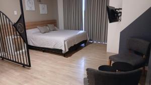 a bedroom with a bed and a chair and a staircase at zona balcarce in Salta