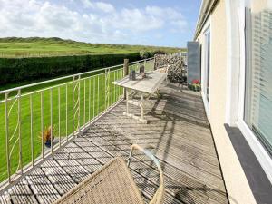 a patio with a table and chairs on a balcony at Mill Cottage in Aberdyfi