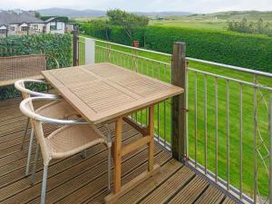 a wooden table and a chair on a deck at Mill Cottage in Aberdyfi