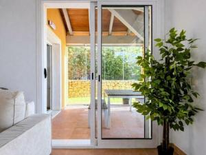 a living room with glass doors and a potted plant at Casa Relax in Polop - Jacuzzi and Pool in Polop