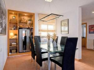 a dining room with a glass table and black chairs at Casa Relax in Polop - Jacuzzi and Pool in Polop