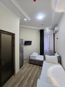 a hotel room with two beds and a tv at ZAAL Hotel in Samarkand +28 photos