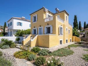 a yellow house with a garden in front of it at Villa Santa Marina in Spetses
