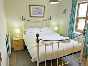 a bedroom with a white bed and two lamps at Elder Cottage - Uk51371 in Winston