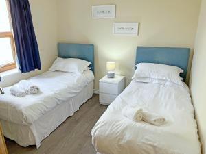 two beds sitting next to each other in a bedroom at Elder Cottage - Uk51371 in Winston