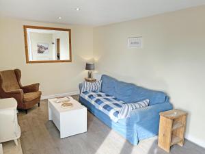 a living room with a blue couch and a chair at Elder Cottage - Uk51371 in Winston