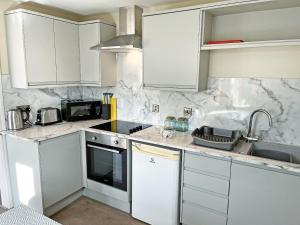 a kitchen with white cabinets and a sink at Elder Cottage - Uk51371 in Winston +4 photos