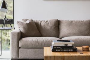 a pile of books on a coffee table in front of a couch at Sterling Treehouse in Stowe Fork