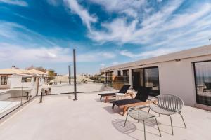 a balcony with chairs and tables on a building at Aetheria South in Kourouta