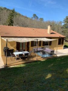 a house with a deck with a table and chairs at Gîte l'Arbre de vie 24 in Nabirat
