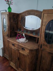 a dresser with a mirror and a vase of flowers at Huone 2-4 henkilölle Inkoossa in Inkoo
