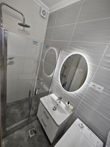 a bathroom with a sink and a shower and a mirror at Barcika Prémium Stúdió in Kazincbarcika