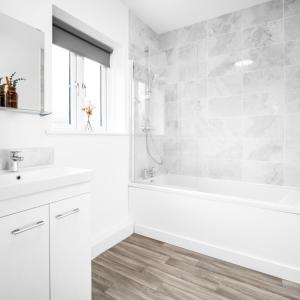 a white bathroom with a tub and a sink at Stylish Two Bed Apartment - Parking - Sleeps 3 - Netflix 55C in Sleightholme