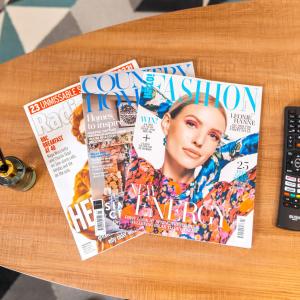 a table with a bunch of magazines on it at Stylish Two Bed Apartment - Parking - Sleeps 3 - Netflix 55C in Sleightholme