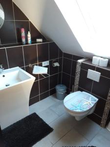 a bathroom with a toilet and a sink at Haus Morgenstern Fewo Boben in Neuharlingersiel +18 photos