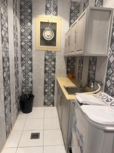 a small kitchen with white cabinets and a sink at رفاه الماسي in Medina