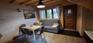 a room with a couch and a table and a door at Domki Obertyny in Wetlina