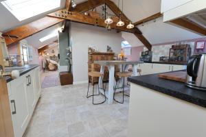 a kitchen with a table and stools in it at Harbour View Penthouse in Lowestoft