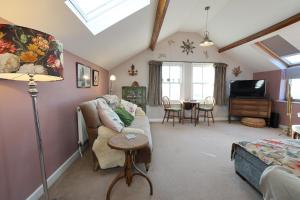 a living room with a couch and a table at Harbour View Penthouse in Lowestoft