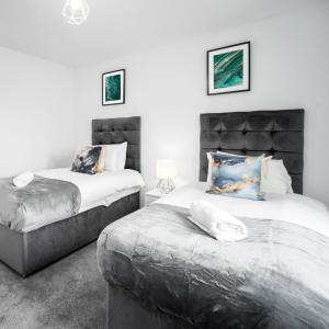 a bedroom with two beds and a headboard at Stylish Two Bed Apartment - Parking - Sleeps 3 - Netflix 55C in Sleightholme +27 photos