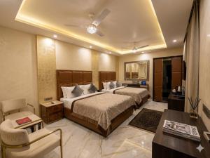 a hotel room with two beds and a table at Hotel Grand Gtois -Delhi Airport in Dunya