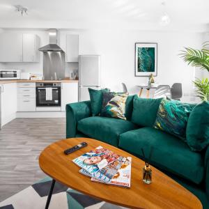 a living room with a green couch and a table at Stylish Two Bed Apartment - Parking - Sleeps 3 - Netflix 55C in Sleightholme