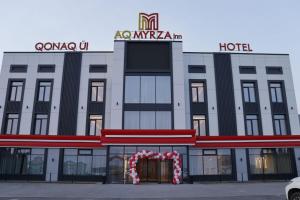 a hotel with a sign on top of it at AQMYRZA Inn in Zharkent