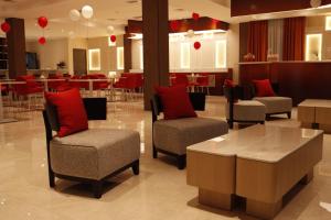 a lobby with chairs and a table and a restaurant at AQMYRZA Inn in Zharkent