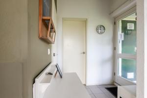 a kitchen with a sink and a clock on the wall at Rekerlande 274 in Warmenhuizen +21 photos