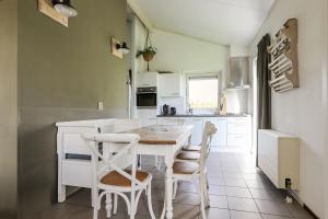 a kitchen with a white table and chairs at Rekerlande 274 in Warmenhuizen