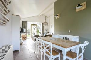 a kitchen and dining room with a wooden table and chairs at Rekerlande 274 in Warmenhuizen