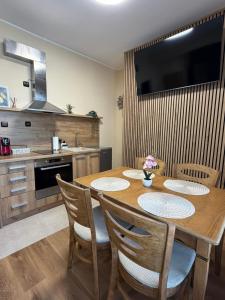 a kitchen with a wooden table with chairs and a television at ValMar Guest rooms in Haskovo +21 photos