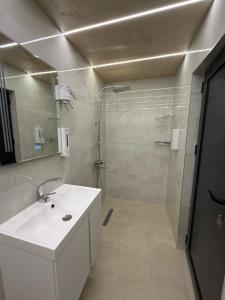 a bathroom with a white sink and a shower at ValMar Guest rooms in Haskovo