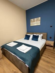 a bedroom with a large bed with towels on it at ValMar Guest rooms in Haskovo