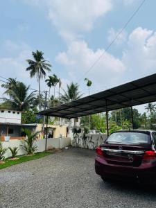 a car parked under a canopy in a parking lot at Jimmy nivas in Kottayam