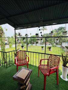two red chairs and a table under a tent at Jimmy nivas in Kottayam