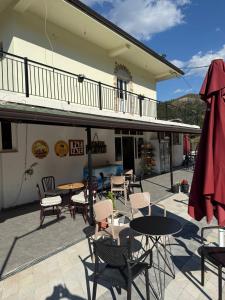 a patio with tables and chairs and a building at Antoni Guest House & Café in Lekaj