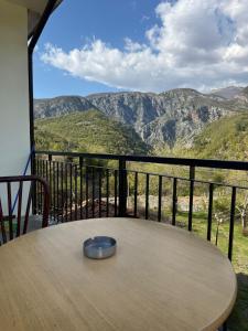 a table on a balcony with a view of mountains at Antoni Guest House & Café in Lekaj