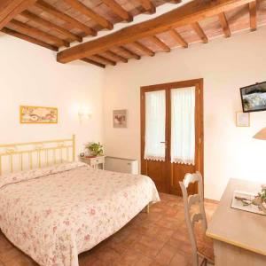 a bedroom with a bed and a desk and a table at B&B Le Cascatelle di Saturnia in Saturnia
