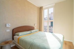 a bedroom with a bed and a large window at Sul Corso Sanremo in Sanremo