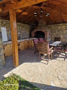 a patio with a table and chairs and a fireplace at Apartmani Lux Nina in Vrdnik
