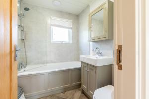 a bathroom with a bath tub and a sink at Landal Aysgarth in Aysgarth +27 photos
