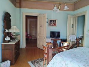 a bedroom with a bed and a desk and a television at Proctor Mansion Inn in Wrentham
