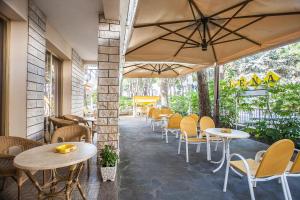 a restaurant with tables and chairs and an umbrella at Hotel Milena in Cervia