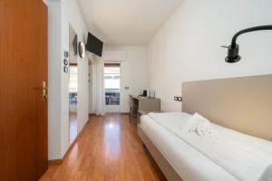 a bedroom with a white bed and a desk at Ventus Park Hotel in Nago-Torbole +61 photos