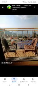 a balcony with two chairs and a table on a ship at Cecil homes hotel in Murree
