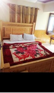 a bedroom with a bed with a dragon blanket on it at Cecil homes hotel in Murree +2 photos