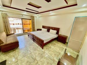 a bedroom with a bed and a chair in it at Cecil homes hotel in Murree
