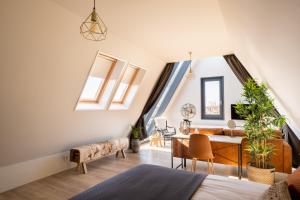 an attic room with a table and chairs and a dining room at Yn 'e Haven Logies in Earnewâld